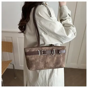 Primer plano detallado de un bolso de hombro retro marrón con elegante diseño de hebilla.