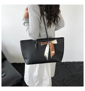 Classica borsa shopper in pelle nera con foulard di seta, borsa a spalla minimalista ed elegante.