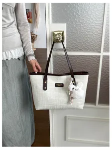 Classic vintage canvas tote bag with brown leather handles and cute plush bunny charm.
