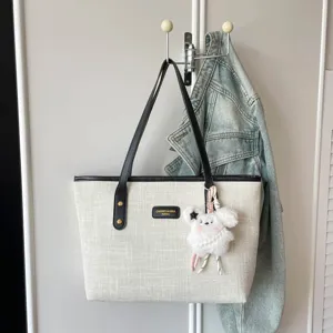 Casual canvas tote bag retro minimalist shoulder handbag with cute plush pendant for daily commute.