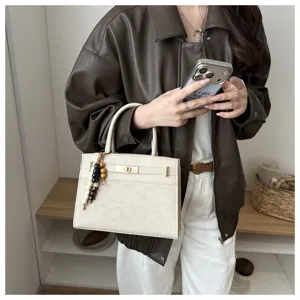 Elegante Damen Handtasche im minimalistischen Design mit feinem Leder und Perlenanhänger.
