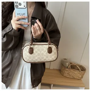 Retro monogram bowling bag with brown leather trim and top handles for women stylish daily use.