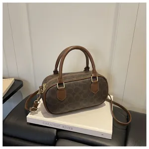 Vintage brown monogram bowling bag detail, top handle and adjustable strap, chic daily style.