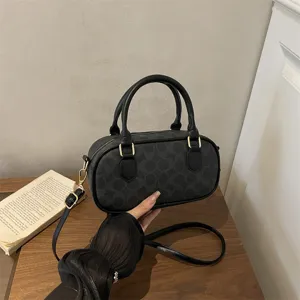 Classic black monogram barrel shoulder bag, retro bowling handbag with top handles and strap.