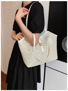 Gedetailleerd overzicht van modieuze grote casual shopper tas met print en metalen slot.