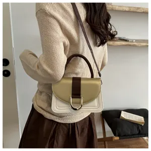 Primo piano dettagliato di una borsa bicolore chic con anello in metallo e tracolla.