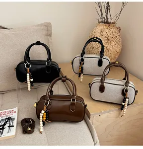 Vista detallada de elegantes bolsos de boliche en varios colores con hermosos abalorios.