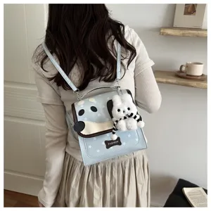 Detail shot of cute cartoon dog backpack with plush pendant, stylish student casual schoolbag.