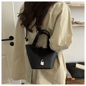 Detailed view of the black leather bucket shoulder bag with silver padlock and double handles.