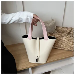 Two-tone leather bucket bag detail view, elegant shoulder bag with chic padlock design.