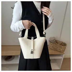 Chic bucket shoulder bag for women, stylish solid color leather handbag with lock detail.