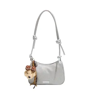 Silver metallic woven shoulder underarm pillow bag featuring a cute puppy plush charm.