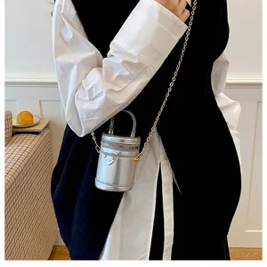 Vue détaillée du mini sac seau métallique argenté, fermeture éclair avec bandoulière.