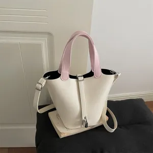 Chic pink and white bucket bag for women, stylish niche design shoulder bag with lock detail.