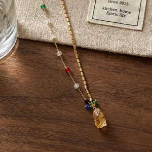 Elegant gold-toned clavicle necklace featuring colorful beads and a sparkling yellow crystal pendant.