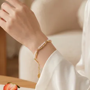 Exquisite double-layer pearl and gold metal bracelet detail, elegant close-up jewelry shot.