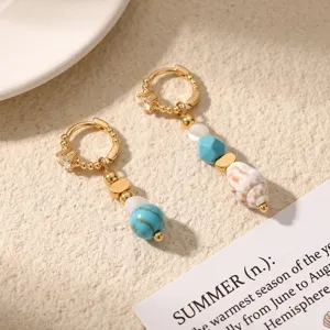 Detail view of exquisite gold-plated hoop earrings featuring turquoise beads, pearls, shell.