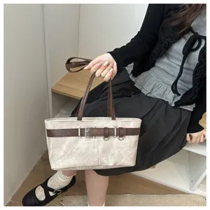 Vista detallada de bolso de hombro vintage para mujer con diseño de cinturón chic y doble asa.