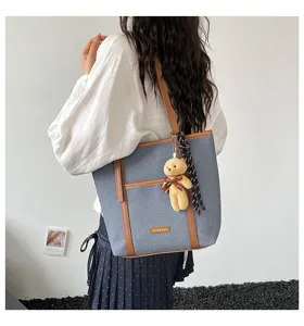 Detailed view of the woven tote bag showcasing textured fabric, PU trim, and cute teddy bear.