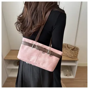 Vista detallada del elegante bolso de hombro rosa para mujer con correas marrones y hebilla metálica.