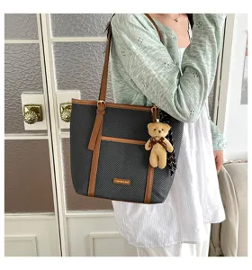 Detailed view of large capacity black brown tote bag with cute plush bear pendant lifestyle.