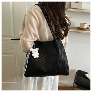 Black woven tote bag with chain strap and cute rabbit pendant for women daily commuting.