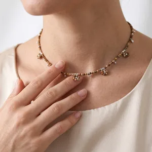 Exquisite bohemian beaded choker necklace with cute flower charms and silver metal accents.