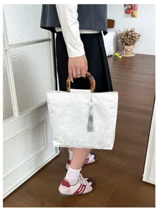 Sac à main blanc style chinois avec poignée en bambou et pendentif gland élégant détail