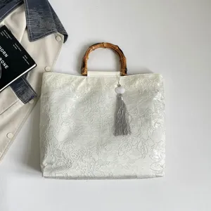 Elegante weiße Jacquard Handtasche im chinesischen Stil mit Bambusgriff und Quaste.