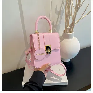 Roze leren mini crossbodytas detailweergave met chique gouden slot en leuke hanger.