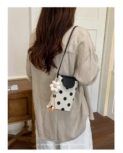 Schicke Mini-Umhängetasche aus Canvas mit Polka-Dot-Muster und süßem Gänseblümchen-Anhänger.