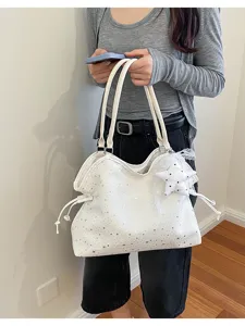 Detail shot of the white star-patterned tote bag featuring a cute lace star pendant and strap.