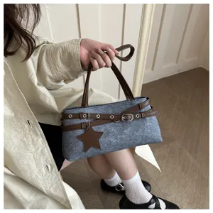 Detailed view of a grey textured shoulder bag with brown straps and star charm pendant.