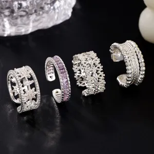 Set di 4 anelli regolabili in argento con stella, zirconi viola e motivi traforati.