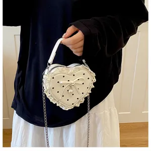 Korean style polka dot heart children's bag with lace bow and chain strap for girls.