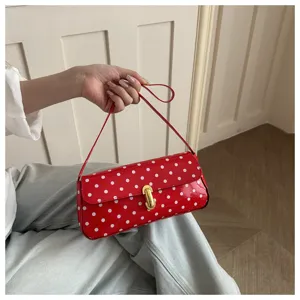 Red polka dot shoulder underarm bag, stylish women commuting baguette handbag for daily use.