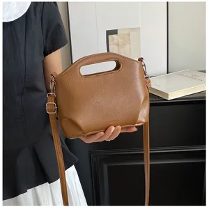 Sac à bandoulière marron vintage en cuir souple avec poignée supérieure et longue sangle.