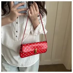 Chic red polka dot patent leather underarm shoulder bag for women, stylish commuting handbag.