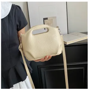Vue détaillée du sac à main en similicuir souple avec poignée et bandoulière réglable.