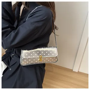 Detail view of a stylish silver polka dot underarm shoulder bag with chic clasp for women.