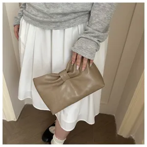 Détail de pochette nuage plissée nœud, style sac de soirée élégant, accessoire tendance.