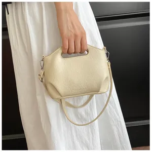 Gros plan detail du sac a main en cuir souple beige avec poignee et sangle tres elegante.
