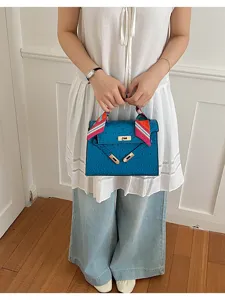 Bolso de hombro azul vista de detalle, diseño trapecio clásico con un pañuelo muy elegante.