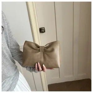 Vue détaillée du sac pochette chic plissé nœud cloud avec une texture de design unique.