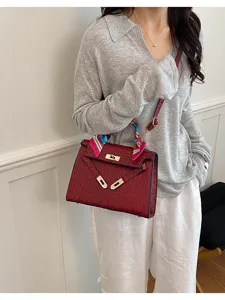 Elegante bolso de hombro rojo con patrón de avestruz y bufanda para el uso diario y la moda.