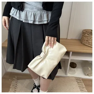 Vue de détail de la pochette beige plissée dotée d'un élégant nœud pour les soirées chic.