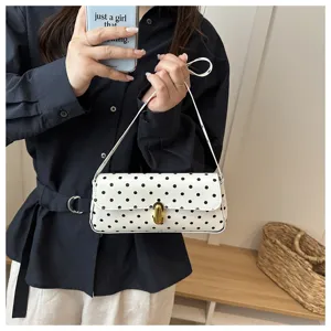 Detailed shot of a stylish white polka dot shoulder underarm bag, perfect for daily commuting.