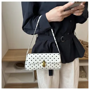 Chic white black polka dot shoulder baguette baguette bag for women, stylish commuting handbag.