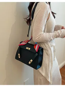Bolso bandolera negro con relieve de avestruz, cierre metálico y pañuelo de seda para mujer.