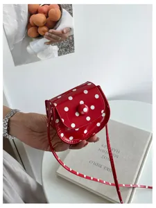 Detail der roten Mini-Umhängetasche mit Punkten, süße PU-Leder-Tasche, schicke Schultertasche.